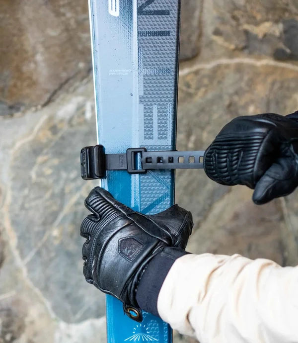 Spänn fast bandet runt båda skidorna